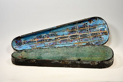 Thomas Virnich (*1957) | Ornamentales Glasgebirge auf Bleigrund, 1990, ramponierter Geigenkasten, bemalt; Blei, Flachglas, Silikon, 76,5 × 24 × 15 cm, erworben 2020