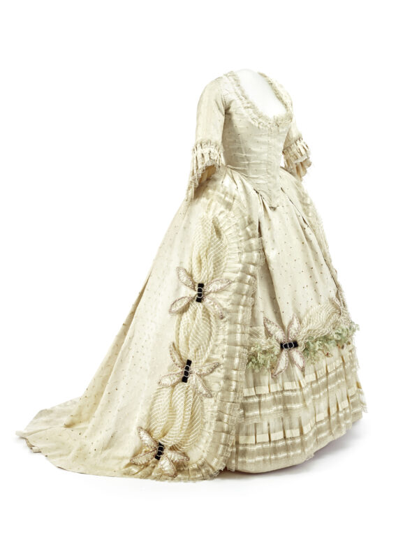 Rokoko Kleid, um 1750 130 × 80 cm Cremefarbene Seide und Seidendamast mit Lochstickerei, Seiden- und Klöppelspitzen, aufgesetzte Dekoration in Form von gerüschten und gefälteten Volantes sowie Stoffblattwerk, Applikationen mit Perlenstickerei und schwarzen Samtschleifen mit Strassspangen Düsseldorf, Kunstpalast Foto: © Kunstpalast - LVR-ZMB - Annette Hiller – ARTOTHEK