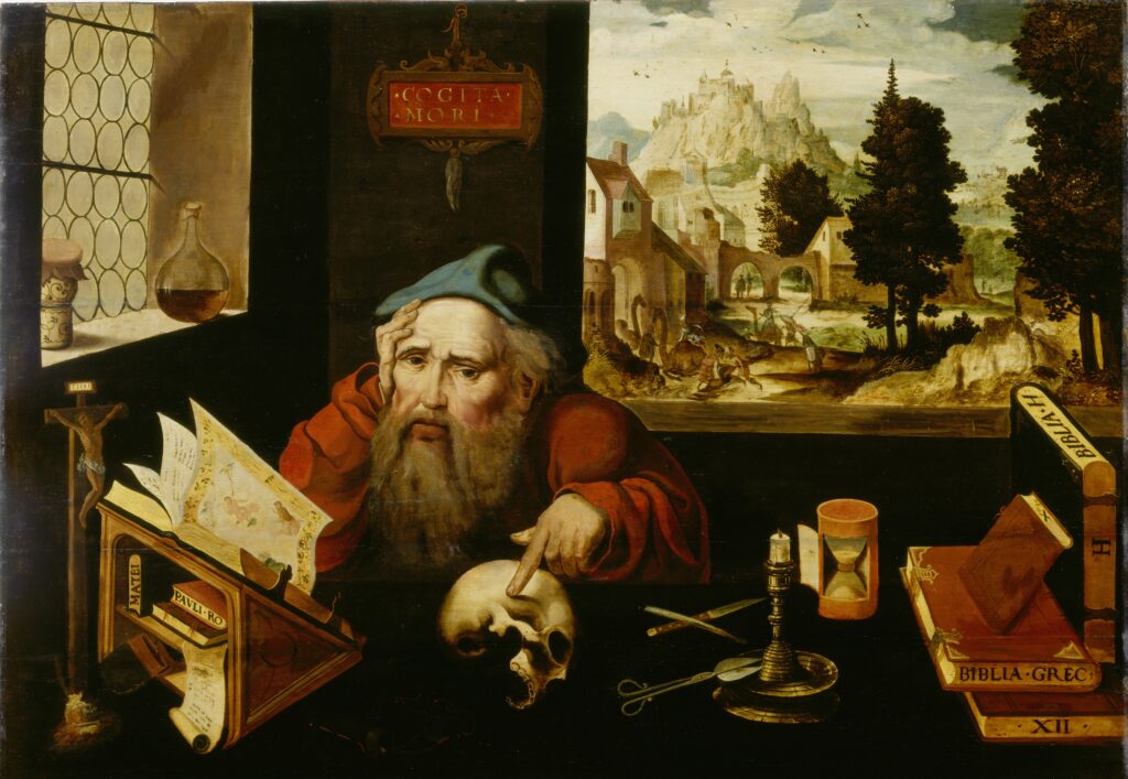 Ein älterer Mann zeigt in einem Arbeitszimmer auf einen Schädel, der von Büchern und wissenschaftlichen Instrumenten umgeben ist, während durch das Fenster eine Landschaft zu sehen ist.